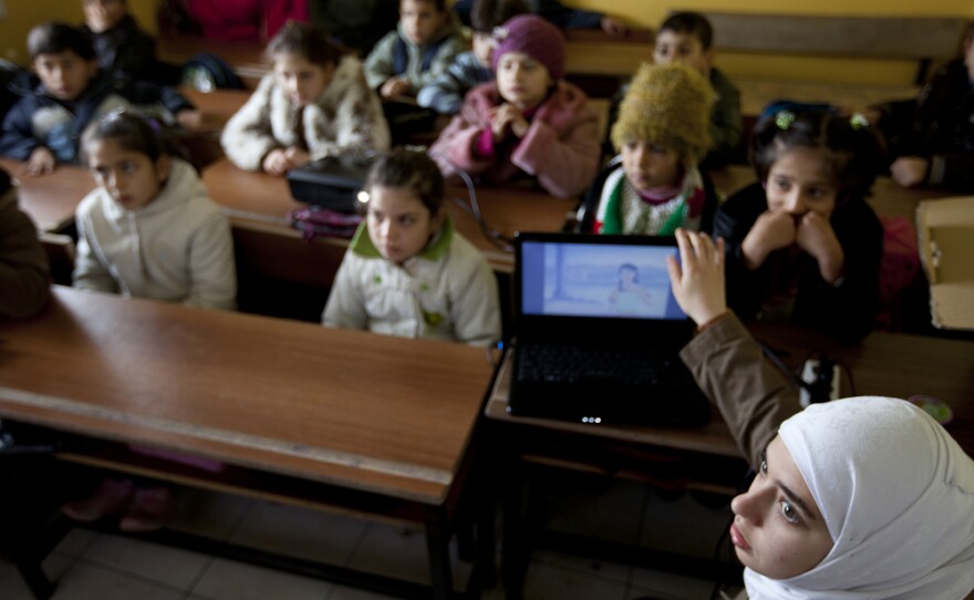 Teacher Rahaf Al Tinawie sets up a DVD player to show a video-story to her students. Tinawie teaches human resources at Albashayer and tries to help the children overcome the trauma most have experienced.