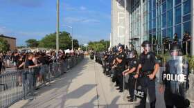 Police in riot gear guarding the Orlando Police Department headquarters as protesters look on, Sunday May 31st. Photo: Matthew Peddie, WMFE