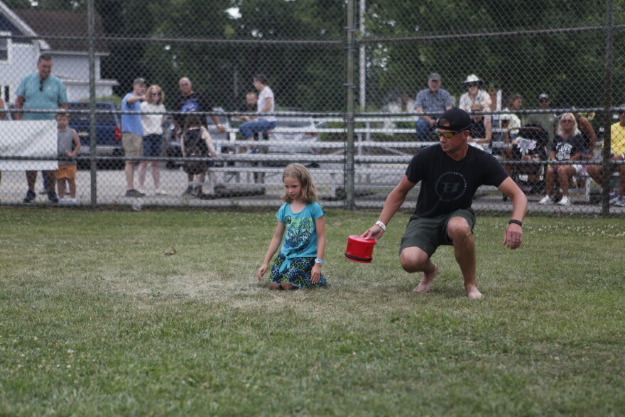 Dugan Hettich helping his daughter Reagan during the Wisconsin State Frog Jump. (credit: Dan Wanschura / Points North)
