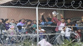 In this March 27, 2019, file photo, Central American migrants wait for food in a pen erected by U.S. Customs and Border Protection to process a surge of migrant families and unaccompanied minors in El Paso, Texas.