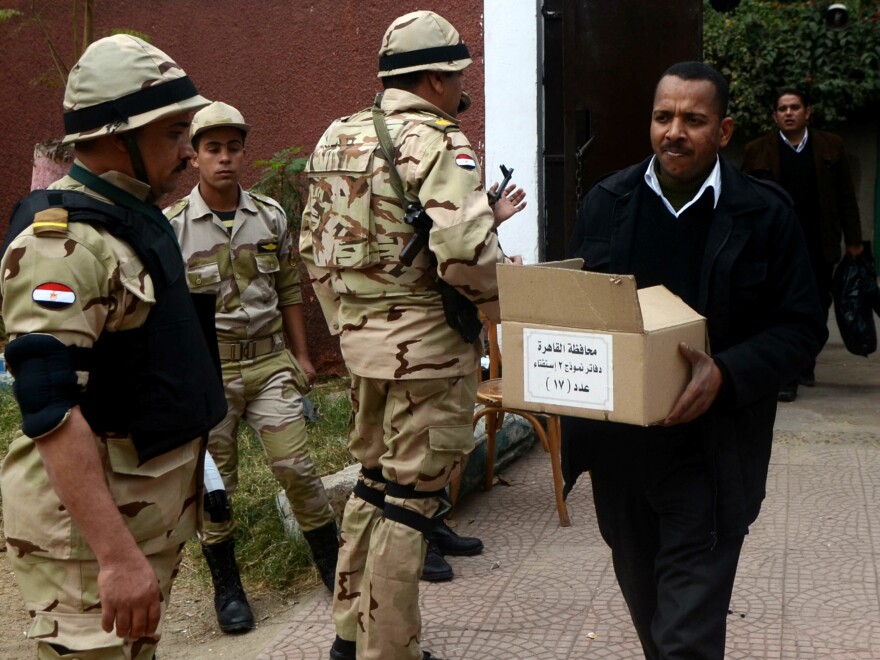 A man carries a box full of voting ballots on Jan. 13 outside a school in Cairo that will be used as a polling station during the constitutional referendum this week.