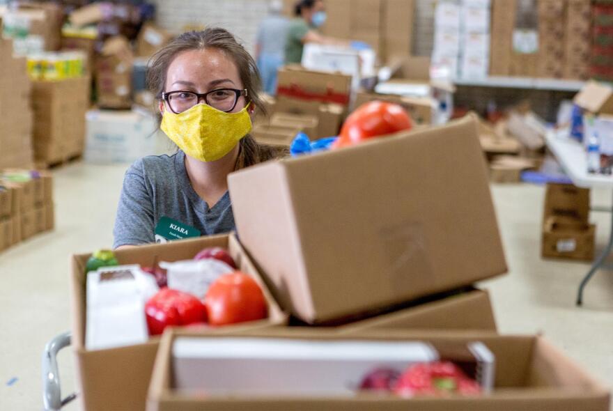 A volunteer prepares boxes of food at the Kelly Memorial Food Pantry in Central El Paso, which has served 700 to 1,000 families a day during the COVID-19 pandemic. 