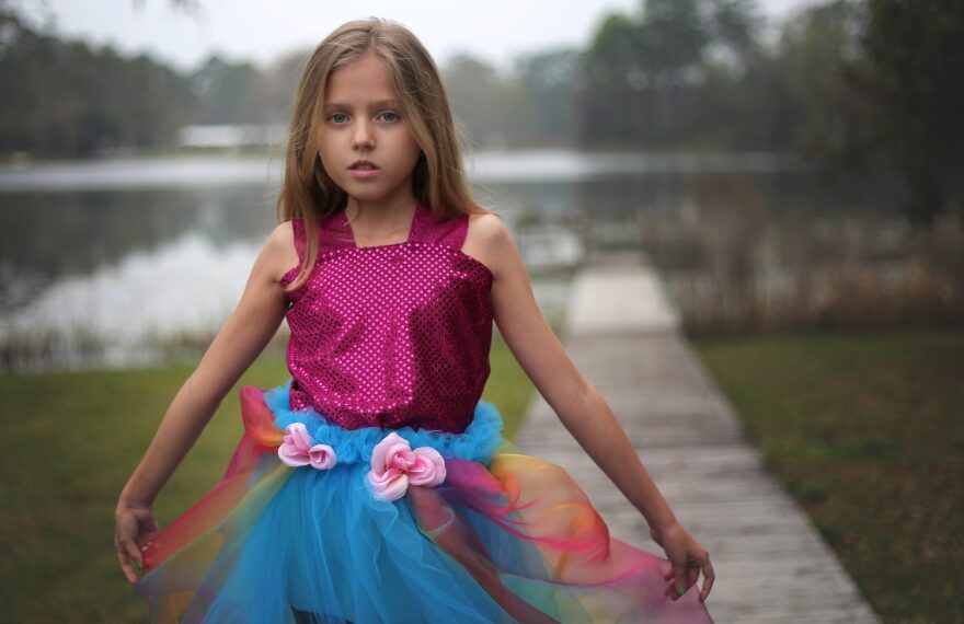 Lily Tallerico, 9, poses outside of her Palatka house in one of the new gowns in her fashion line that will debut Saturday at the Fashion for Freedom runway show. This dress, inspired by the queen of all colors, is Lily’s favorite out of her line of eight dresses.