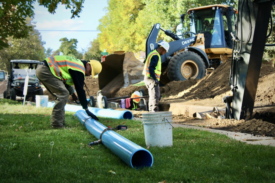 Workers install new PVC pipe under a street in Denver on October 11, 2023. Denver's water department has planned nearly $2 billion in upgrades over the next decade. Many cities in the region are also facing costly infrastructure repairs that will drive up water bills in the coming years.