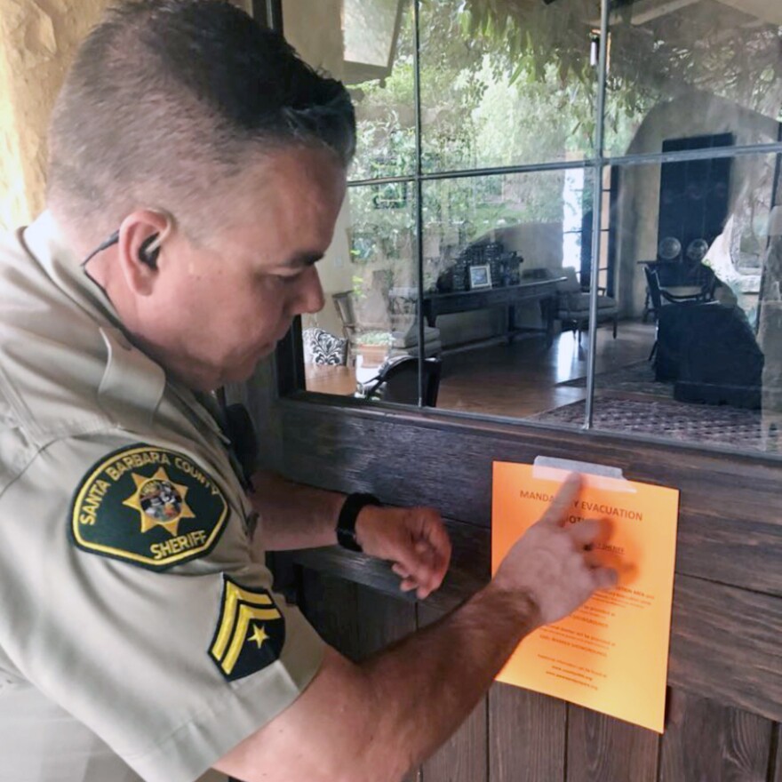 Santa Barbara County Sheriff's Deputy Mike Harris posts a notice on a home near Carpinteria, Calif., advising of the mandatory evacuation. flash flood warnings for the area were lifted around 9:45 a.m. ET, The Associated Press reports.