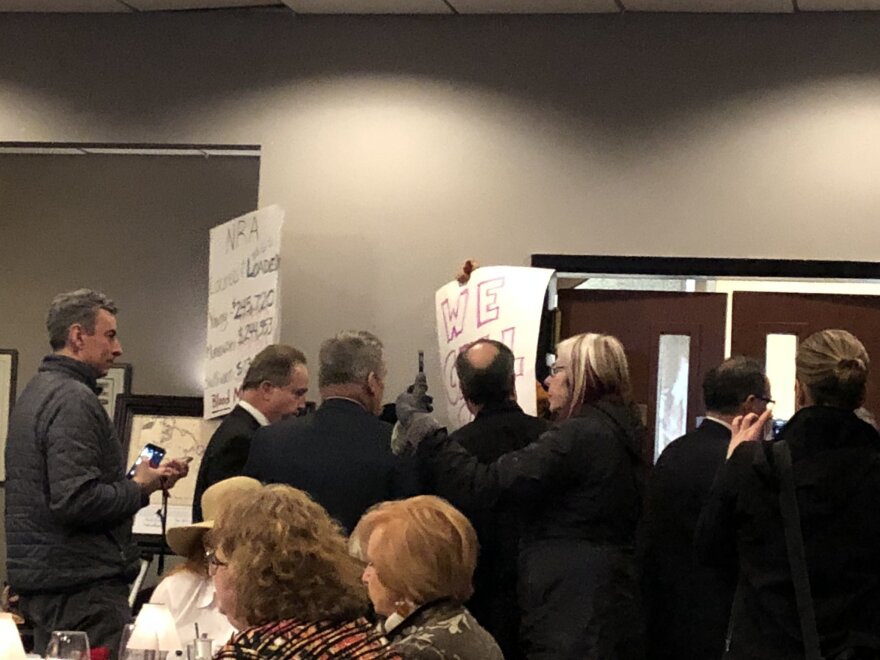 Protesters at an event featuring U.S. Sen. Lisa Murkowski and U.S. Rep. Don Young are quickly ushered out of the room on Monday, Feb. 19, 2018. (Photo by Elizabeth Harball/Alaska’s Energy Desk)