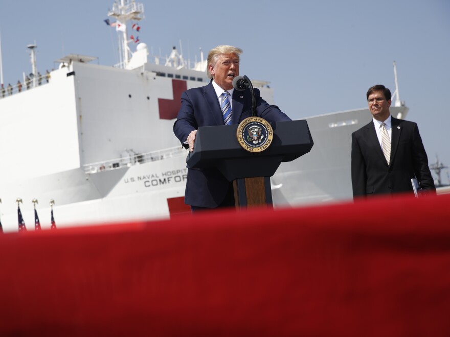 President Trump speaks in front of the USNS Comfort in Norfolk, Va., on Saturday. The ship is departing for New York to assist hospitals responding to the coronavirus outbreak. Defense Secretary Mark Esper is at right.