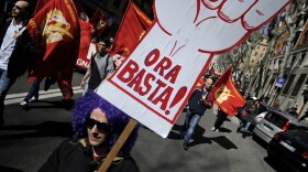 Members of the Italian metalworkers trade union Fiom-CGIL hold a placard reading "Enough now!" during a protest in Rome on March 9. 