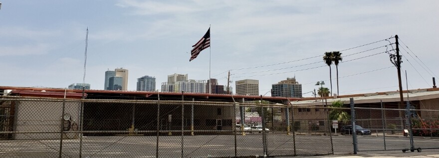 flag flying with downtown skyline in the back