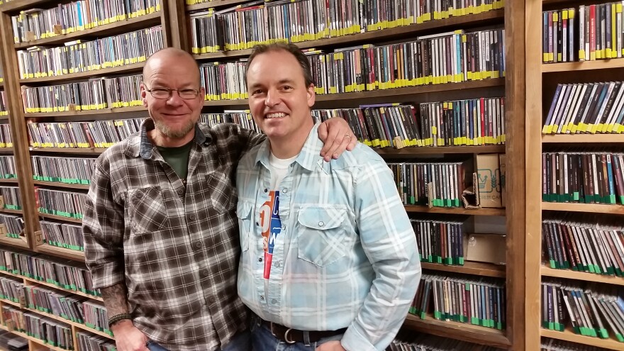 Scotty Robertson and Joe Kendrick standing in front of WNCW's Music Library