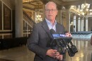 Gov. Mike Braun speaking at the Statehouse. Multiple microphones are in front of him.