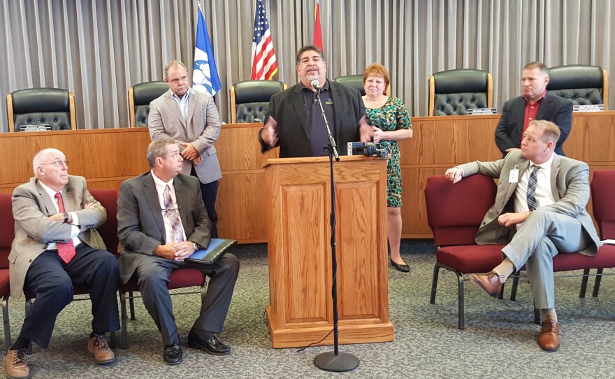 Jorge Perez addresses a crowded city council chambers in Fulton, Mo., after being introduced as the new owner of the town's hospital.