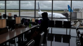 A United Airlines plane is seen in the background as a passenger sits inside the IAH George Bush Intercontinental Airport amid the COVID-19 outbreak in Houston on July 21, 2020.