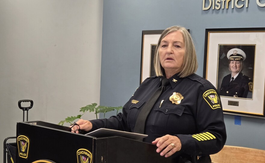 A woman in a police uniform stands at a podium