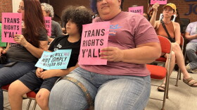 Anice Chenault sits with her child, Justice, at the Jefferson County Board of Education policy committee meeting. They hope JCPS will choose to defy a new state law that limits rights for trans students.