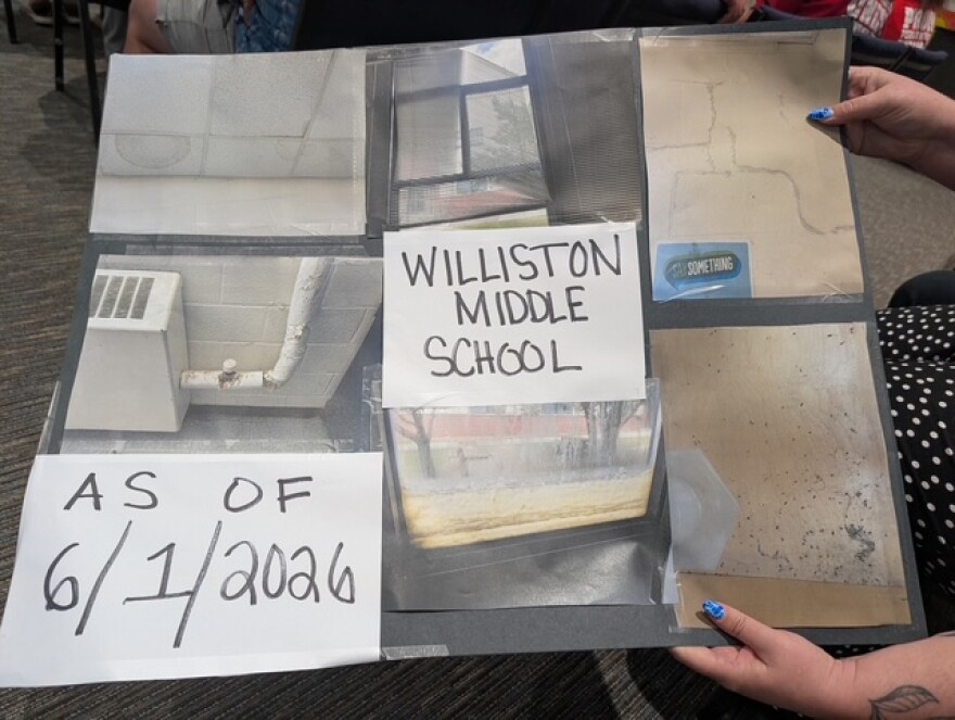 The sign that Clancy Gray's colleague held up while she spoke to the board on June 2, 2026.