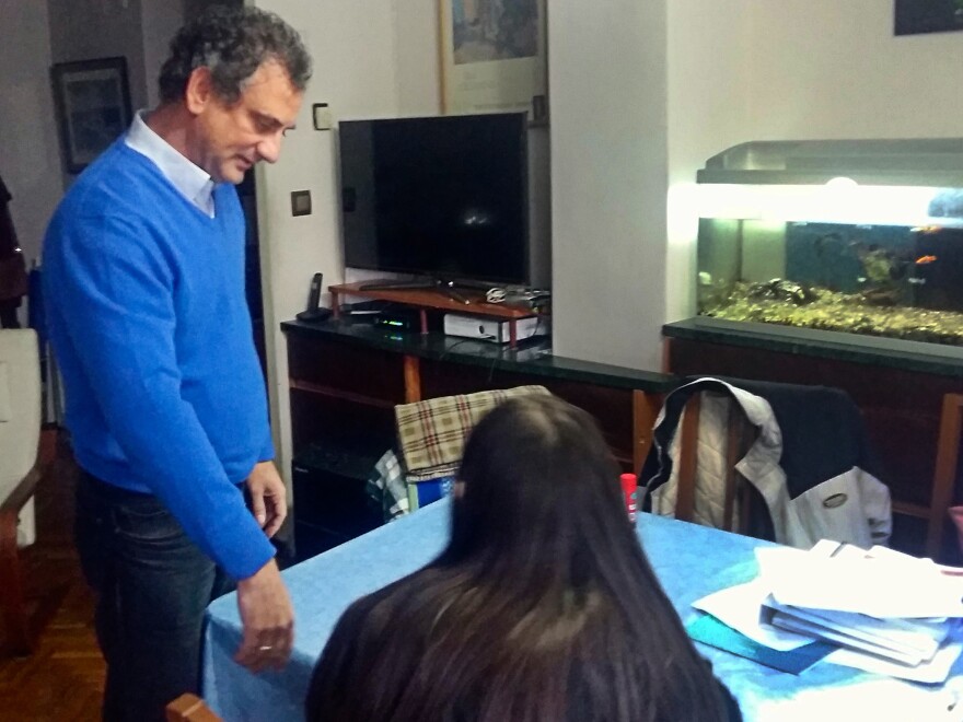 Camilo Jené, 51, watches as his daughter Clara, 14, does her homework at their dining table. She refuses to do homework on weekends now.