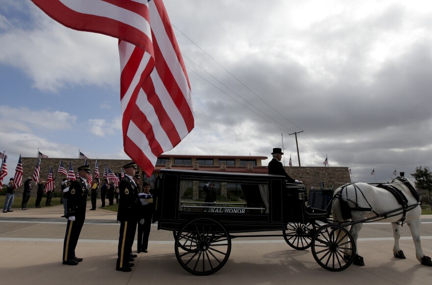 An honor guard places the remains of Army Sgt. Charles Schroeter in the back of a a horse-drawn hearse.