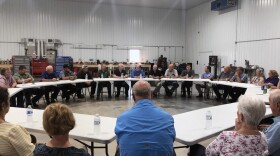 A group of farmers speak with US Senator Mike Bryan (R-IN) at a meeting outside of Evansville.