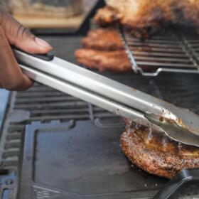 Eric Farley, of the Boys and Girls Club, sears a piece of grilled pork at the World Championship Barbecue Cooking Contest, Friday, May 17, 2024, in Memphis, Tenn. (George Walker IV/AP)