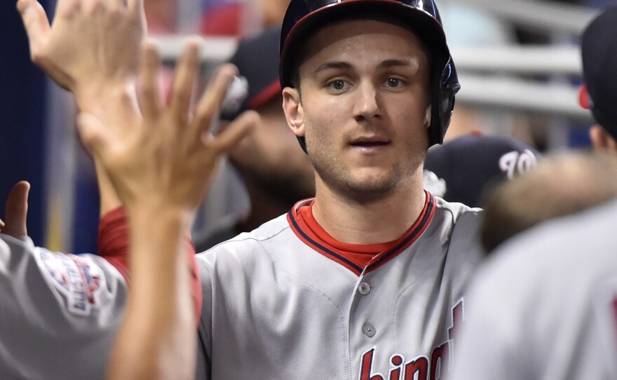 Trea Turner of the Washington Nationals high-fives his teammates after scoring against the Miami Marlins on Friday in Miami.