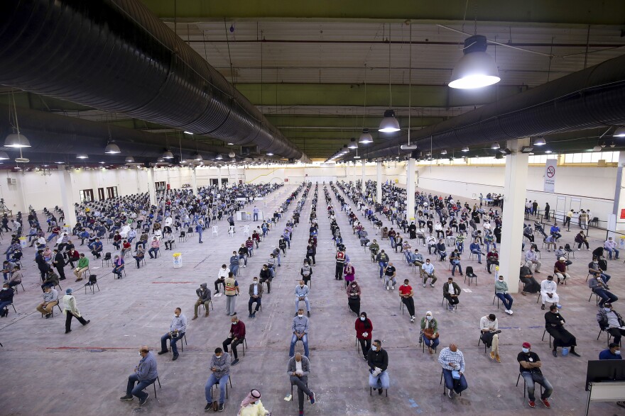 Guest workers from Egypt, Lebanon and Syria wait to be screened for COVID-19 after arriving in Kuwait. The photo was taken in Kuwait City on March 16, 2020.