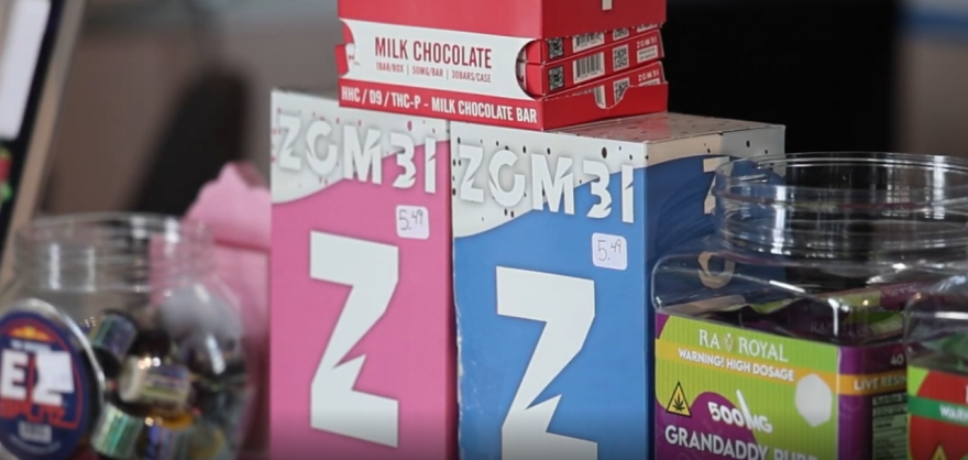 Cajas de gomitas y barras de chocolate infusionadas se muestran junto a otros artículos para la venta en una tienda de humo local. Foto por: Sebastián Broche.