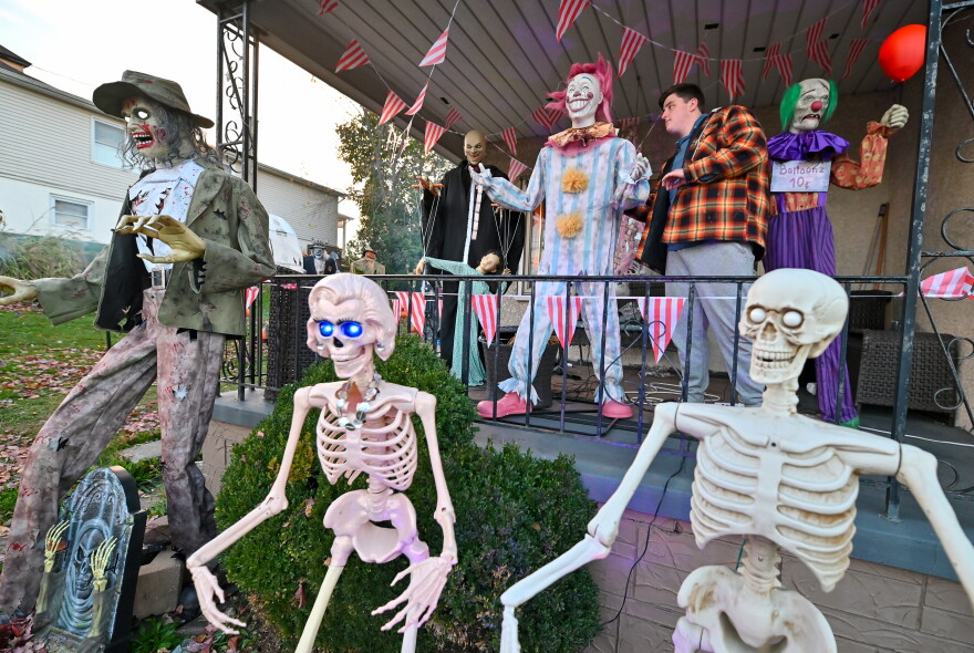 Will Kapmeyer, 15, adjusts one of the clowns on his front porch in Throop. His display will be open for visitors on Halloween.