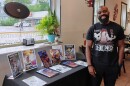 Brandon Colloway standing in front of a table that displays comics from his company.