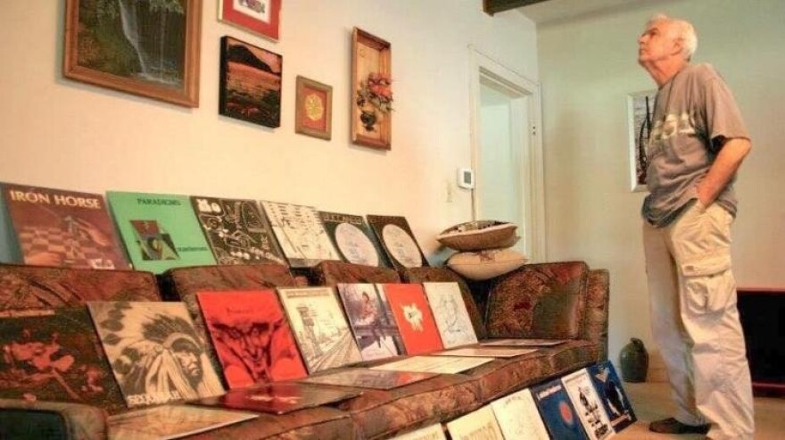 Moe Whittemore stands in his home. Several records that he produced at 700 West Recording Studio are displayed.