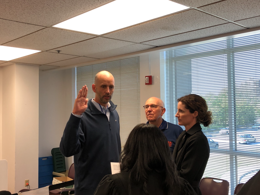 Ryan Mears takes an oath into office. He is joined by former county prosecutor Terry Curry and wife, Shannon Mears.