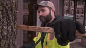 Tyler VanVlerah of Davey Resource Group measures the size of a tree in downtown Columbus. Once the inventory is done, the city will be able to use an interactive map where it can find details about this specific tree.