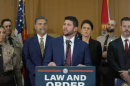 Florida Attorney General James Uthmeier speaks at a podium bearing a “Law and Order” sign during a news conference.
