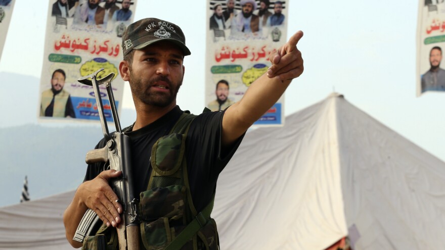 A Pakistani police officer stands guard at the site of Sunday's suicide bomber attack in the Bajur district of Khyber Pakhtunkhwa, Pakistan, Monday, July 31.