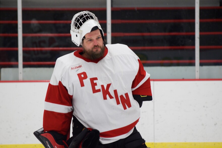 An ice hockey goalie skates off the ice