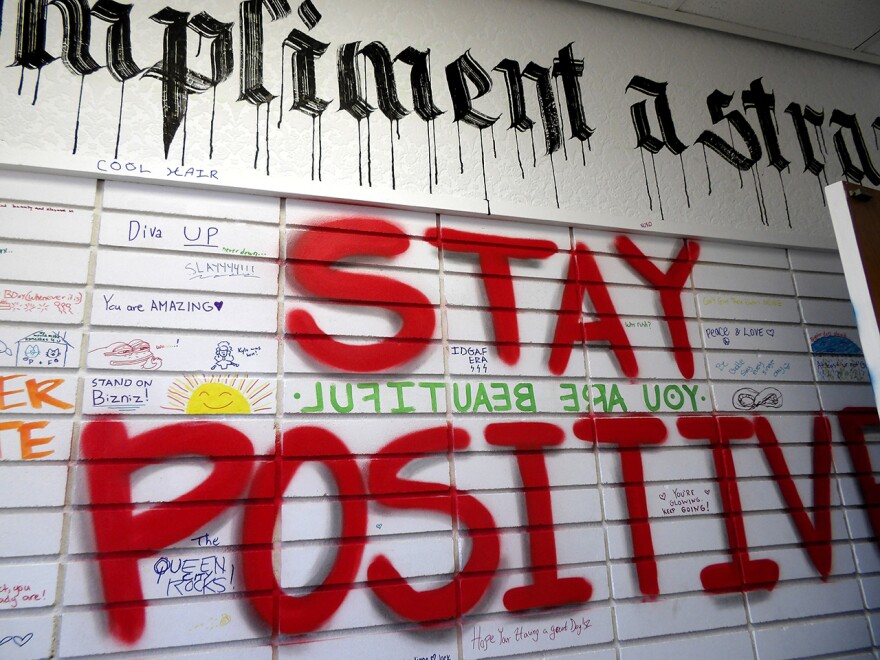 Red writing on a wall says "Stay Positive"