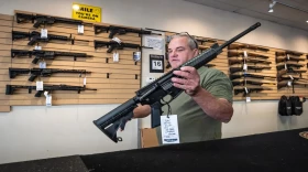 Robert Bevis, owner of Law Weapons and Supply in Naperville, holds an AR-15-style rifle.