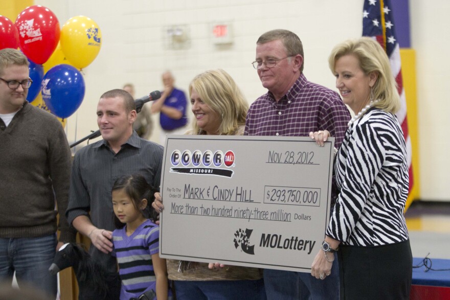 Mark and Cindy Hill hold a check from the Missouri Lottery in Dearborn, Mo., Friday, Nov. 30, 2012.