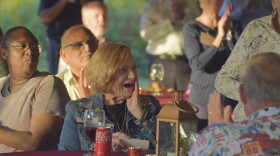 A woman looks at the crowd behind her in surprise. 