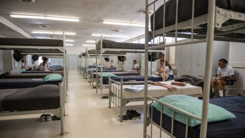 In a 2020 photo, new Air Force recruits in basic training sit in their dormitory at Joint Base San Antonio-Lackland, Texas. Medical experts say the congregate nature of military housing are