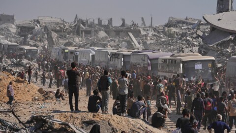 Buses carrying freed Palestinian prisoners drive past destroyed buildings in the Gaza Strip after their release from Israeli jails under a ceasefire agreement between Hamas and Israel, in Khan Younis, southern Gaza Strip, Monday, Oct. 13, 2025.