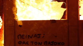 A message on a burning building in the center of Athens saying "Hungry? Eat your local Pasok politician" is seen during the demonstration against the new austerity measures in Syntagma Square on Feb. 12, 2012 in Athens, Greece. Greece's creditors have demanded further austerity measures before approving a new bailout from the European Union.