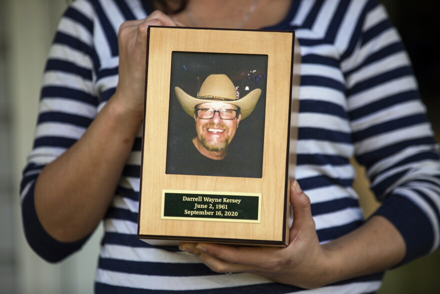 Kelli Kersey holds the ashes of father Darrell Kersey who died of complications from COVID-19 which he tested positive for while incarcerated in the Durham County jail, on Thursday, Oct. 22, 2020, in High Point, N.C.