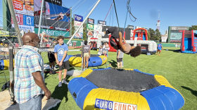 Joe Curtis watches his 11-year-old daughter Myracle have fun on the Eurobungy at Monroe County's America 250 Celebration at ESL Ballpark on Sunday, July 12, 2026.
