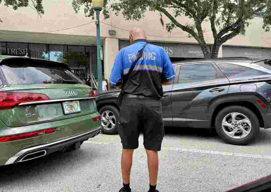 A Sarasota parking enforcement officers patrols downtown on a Wednesday afternoon in August.