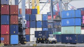 A truck drives past stacks of containers at Jakarta International Container Terminal (JICT) at Tanjung Priok Port in Jakarta, Indonesia, Wednesday, July 9, 2025. (AP Photo/Tatan Syuflana)