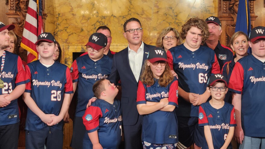 Gov. Josh Shapiro poses for a photo with members of the Wyoming Valley Challenger baseball team.