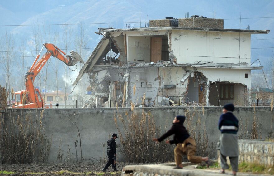 Young Pakistani boys play near demolition works while Osama bin Laden's compound in Pakistan is demolished.