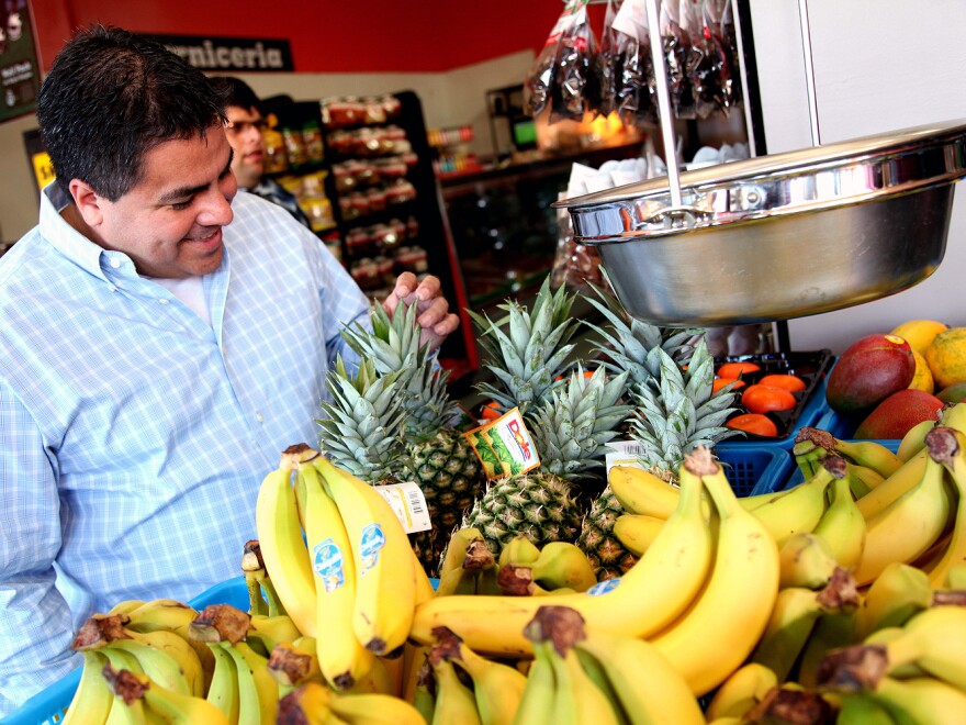 Alex Ortega, a professor of public health at UCLA, looks over the produce at the market he and other community members helped reopen.