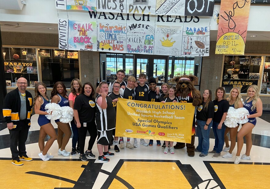 Wasatch High Unified basketball players stand with Principal Justin Kelly (far left), Abby Cox (pink shirt), Jazz Bear and Coach Sami Graham (black shirt, far right) after learning they were chosen to represent Utah in the Special Olympics USA Games.